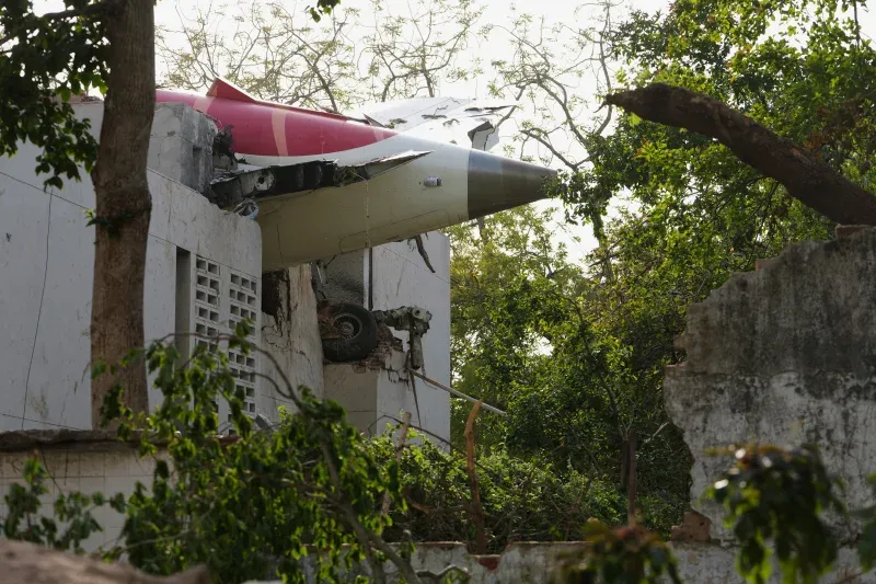 ###### The airplane's tail is lodged in a building at the crash site in Ahmedabad, Gujarat, India, on Thursday, June 12, 2025